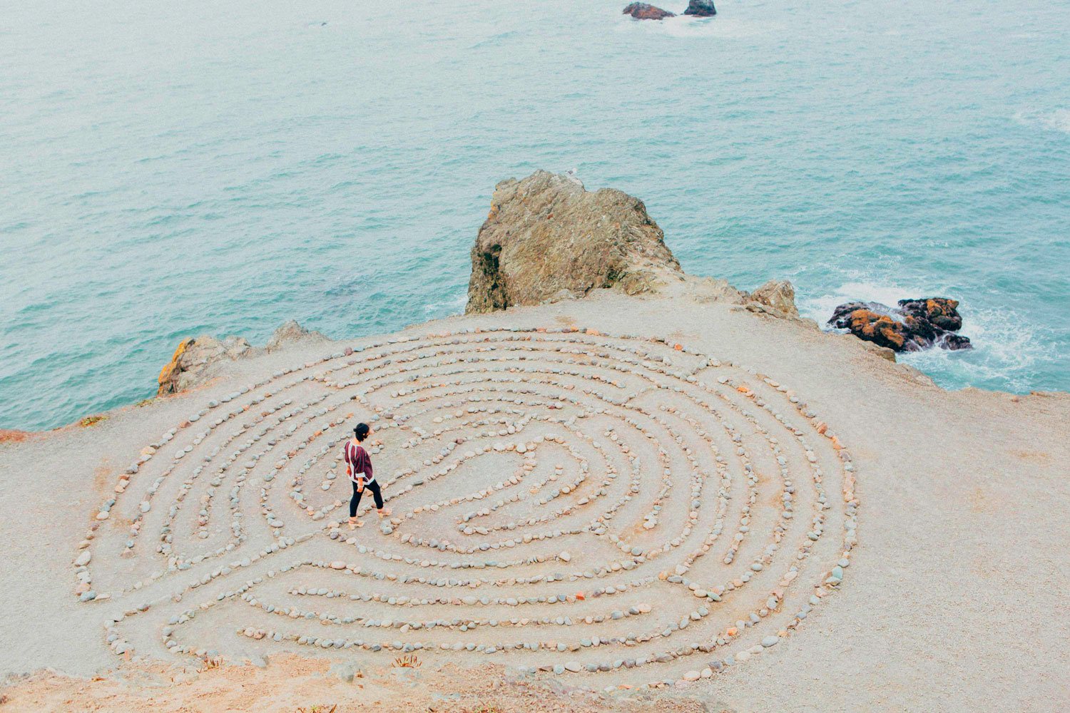 Persona caminando en laberinto de piedras para proceso de inmersión terapéutica